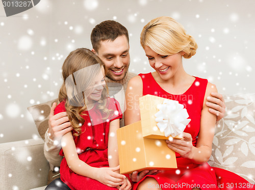 Image of smiling family holding gift box