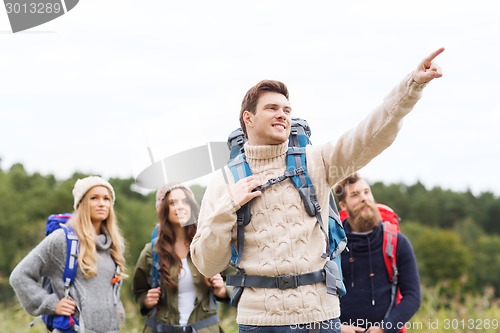 Image of smiling hikers with backpacks pointing finger