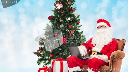 Image of man in costume of santa claus with laptop