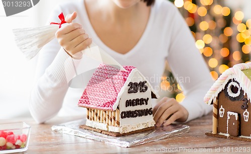 Image of close up of woman making gingerbread houses