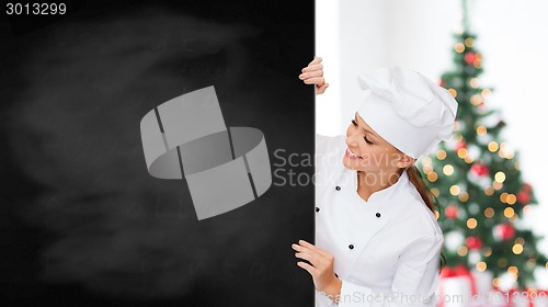 Image of smiling female chef with white blank board