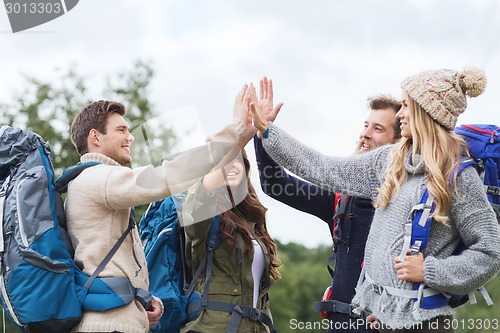 Image of group of smiling friends with backpacks hiking