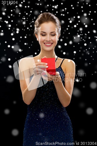 Image of smiling woman holding red gift box
