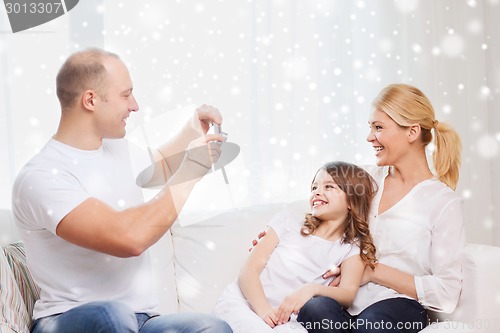 Image of happy family with camera taking picture at home