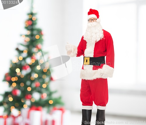 Image of man in costume of santa claus showing thumbs up