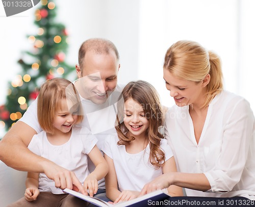 Image of happy family with book at home