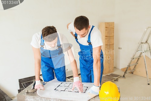 Image of group of builders with blueprint