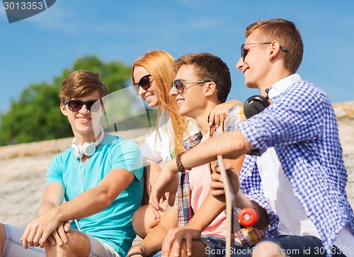 Image of group of smiling friends sitting on city street
