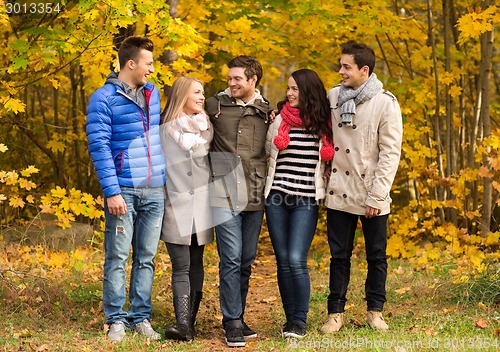 Image of group of smiling men and women in autumn park