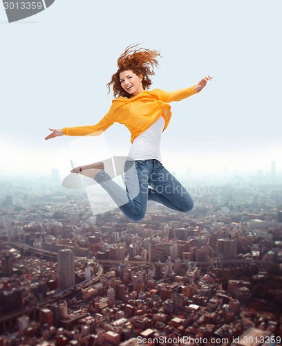 Image of smiling young woman jumping high in air