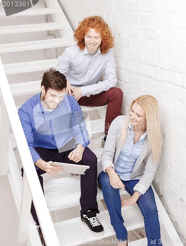 Image of team with tablet pc computer sitting on staircase