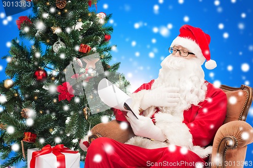 Image of man in costume of santa claus with notepad