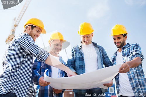 Image of group of builders with tablet pc and blueprint