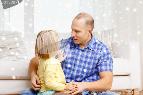 Image of smiling father and daughter hugging at home