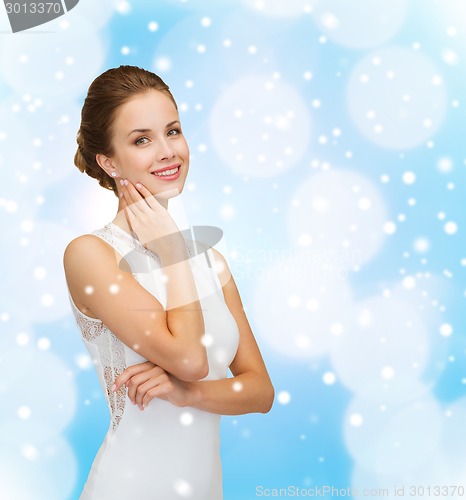 Image of smiling woman in white dress with diamond ring