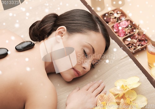 Image of woman in spa salon with hot stones