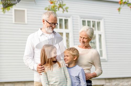 Image of happy family in front of house outdoors