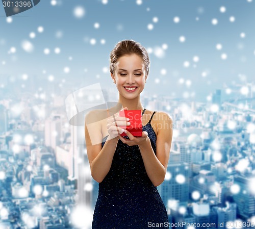 Image of smiling woman holding red gift box