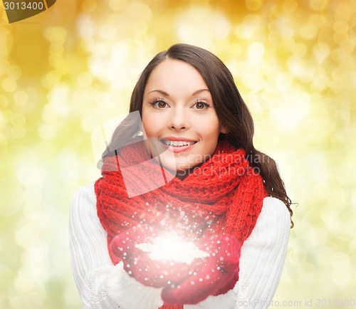 Image of smiling woman in winter clothes with snowflake