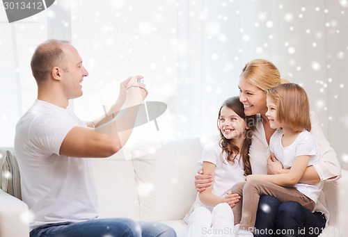 Image of happy family with camera taking picture at home