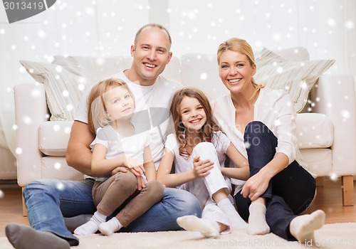 Image of smiling parents and two little girls at home