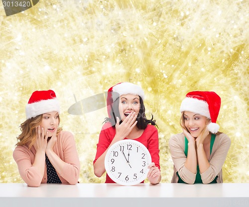 Image of smiling women in santa helper hats with clock