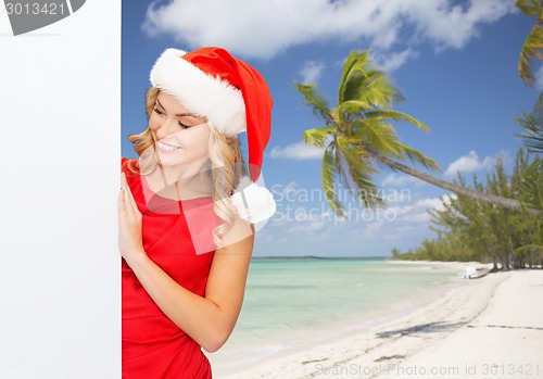 Image of smiling young woman in santa hat with white board