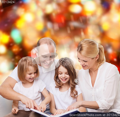 Image of happy family with book at home