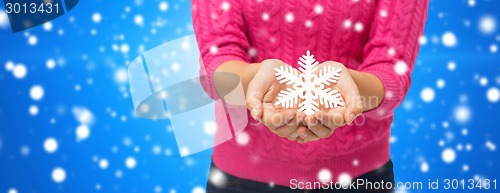 Image of close up of woman holding snowflake decoration