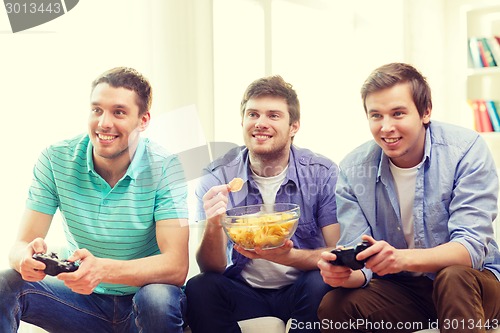 Image of smiling friends playing video games at home