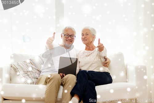 Image of happy senior couple with tablet pc at home