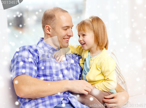 Image of smiling father and daughter hugging at home