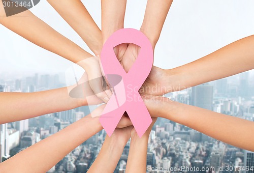 Image of close up of hands with cancer awareness symbol