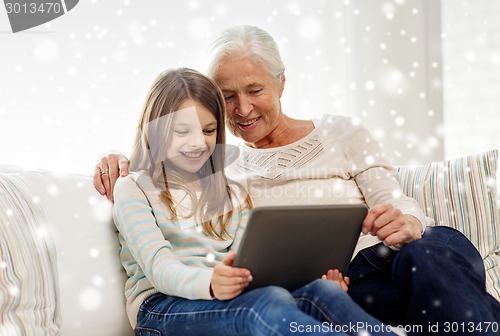 Image of smiling family with tablet pc at home