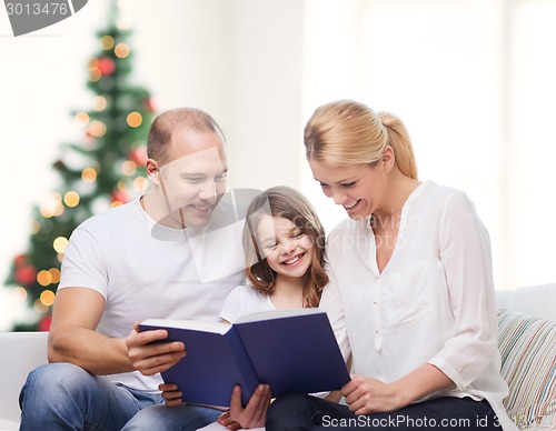 Image of happy family with book at home