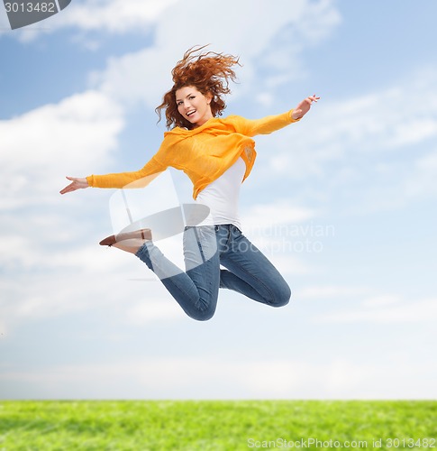 Image of smiling young woman jumping high in air