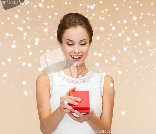 Image of smiling woman holding red gift box