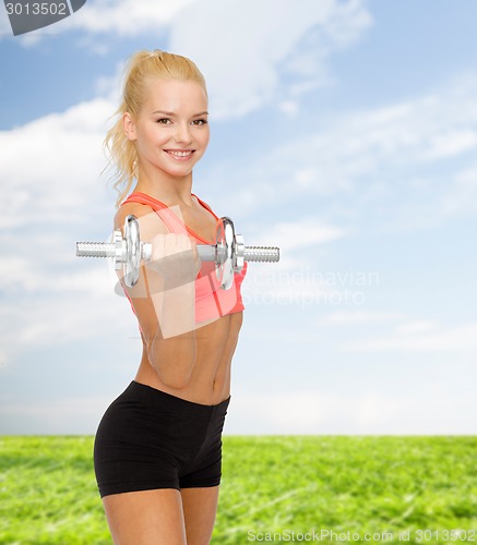 Image of young sporty woman with heavy steel dumbbell