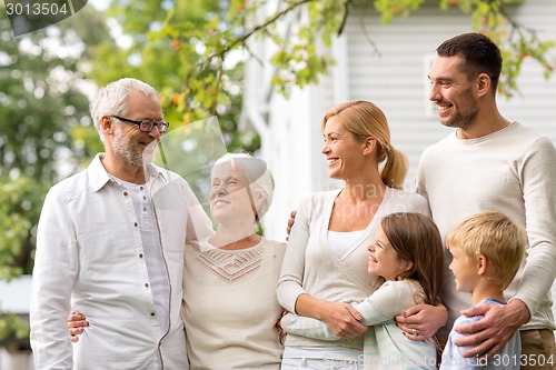 Image of happy family in front of house outdoors