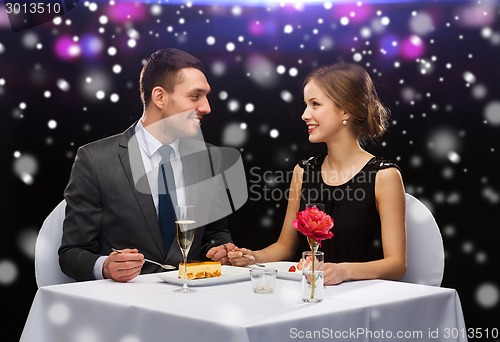 Image of smiling couple eating dessert at restaurant
