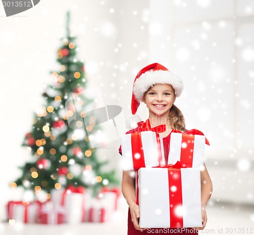 Image of girl in santa helper hat with many gift boxes