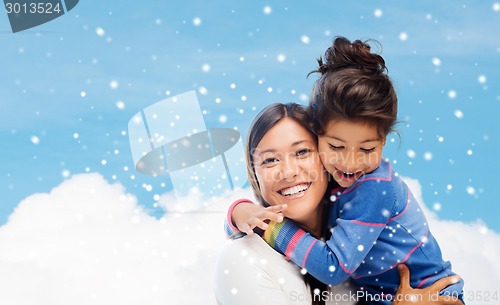 Image of smiling little girl and mother hugging indoors