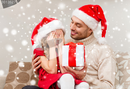 Image of smiling father and daughter holding gift box