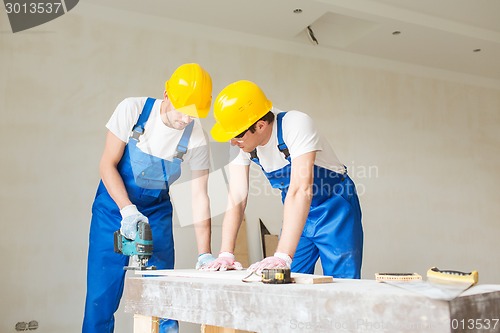 Image of group of builders with tools indoors