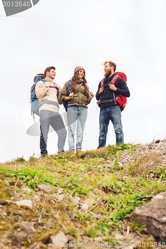 Image of group of smiling friends with backpacks hiking