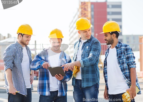 Image of group of smiling builders with tablet pc outdoors