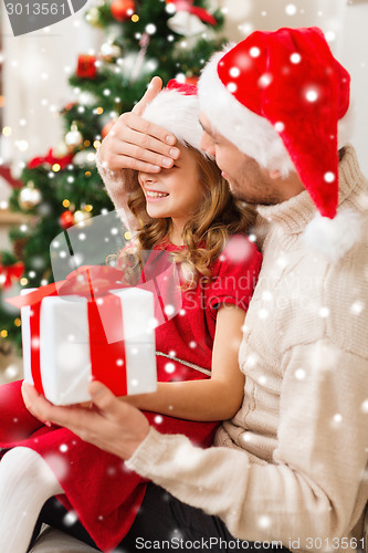 Image of smiling father and daughter holding gift box