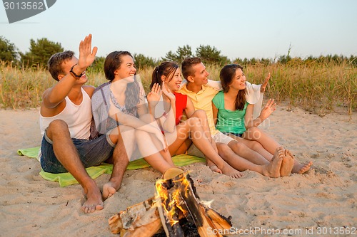 Image of smiling friends in sunglasses on summer beach