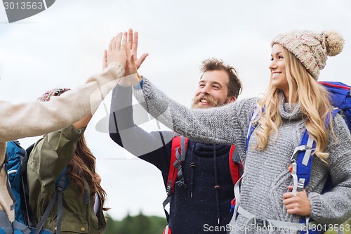 Image of group of smiling friends with backpacks hiking