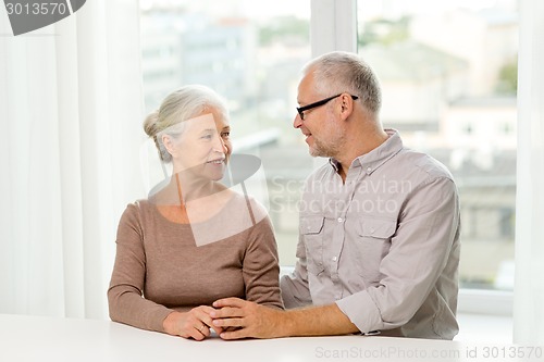 Image of happy senior couple sitting on sofa at home